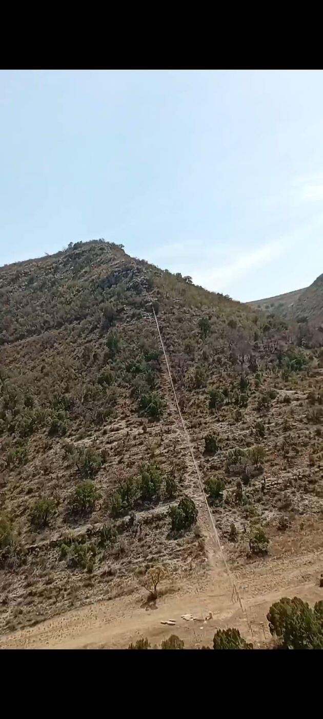 Fence line cleared and built straight up a steep rocky hillside